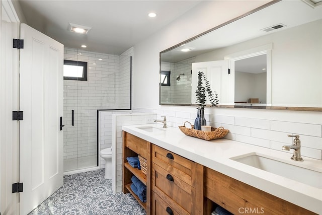 full bath with toilet, a shower stall, visible vents, and a sink