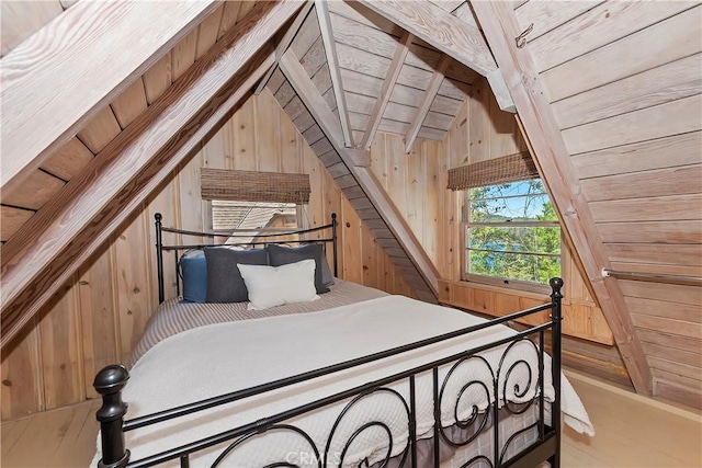 bedroom with lofted ceiling with beams, wooden ceiling, and wood walls