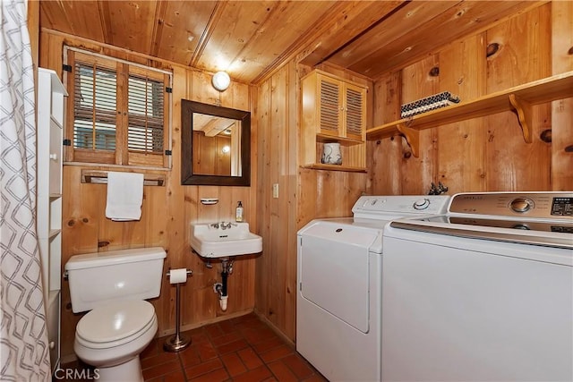 laundry room with wooden walls, separate washer and dryer, wooden ceiling, and sink