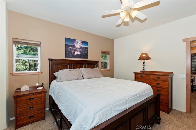 carpeted bedroom with multiple windows and ceiling fan