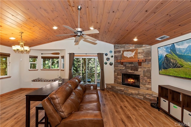 living room featuring ceiling fan, wood ceiling, wood-type flooring, a stone fireplace, and vaulted ceiling