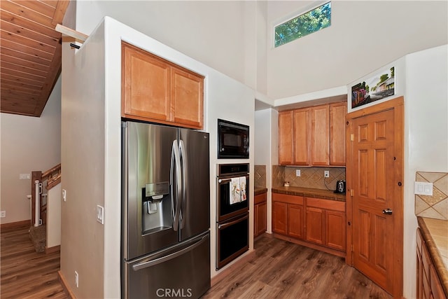 kitchen featuring appliances with stainless steel finishes, backsplash, and dark hardwood / wood-style flooring