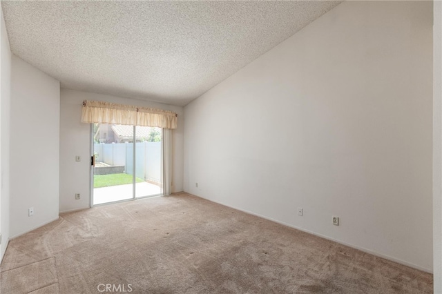 empty room with light carpet, lofted ceiling, and a textured ceiling