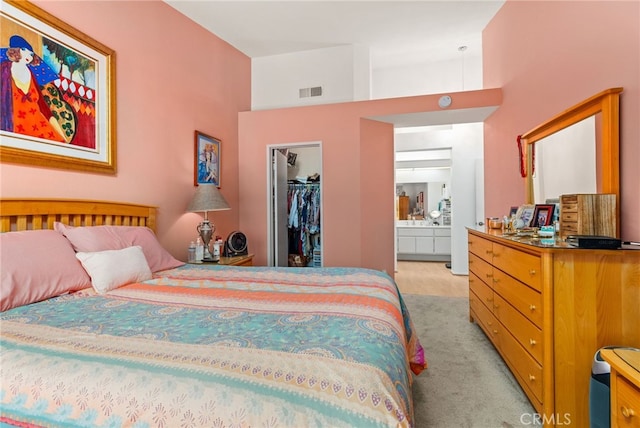 bedroom featuring a walk in closet, ensuite bath, and a closet