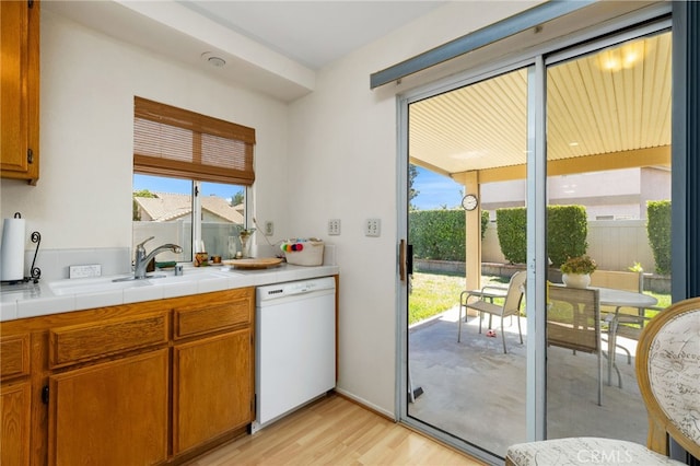 kitchen with sink, a wealth of natural light, tile counters, and dishwasher