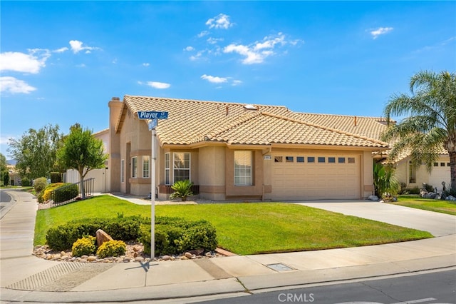 mediterranean / spanish-style home featuring a garage and a front lawn