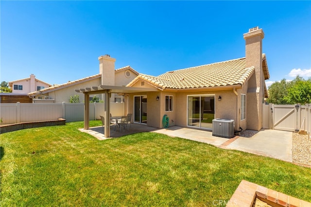 back of house with central AC, a patio area, and a lawn