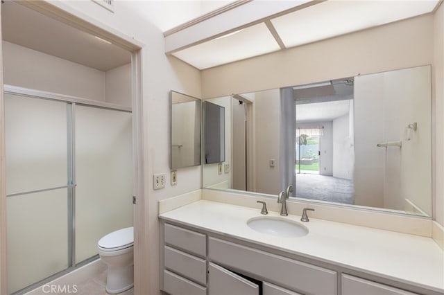 bathroom featuring vanity, an enclosed shower, and toilet