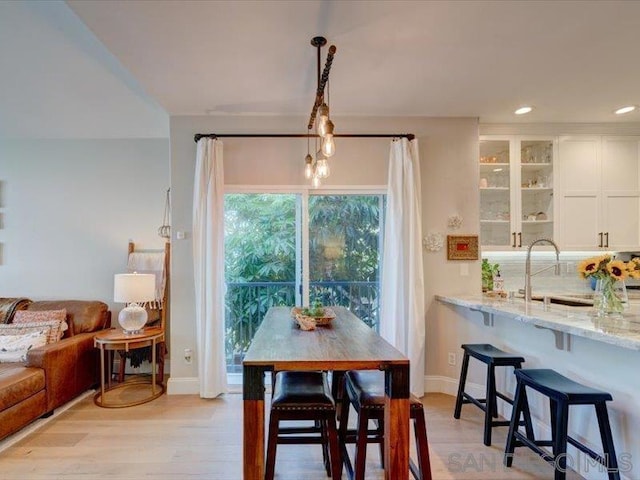 dining space featuring light wood-type flooring and sink