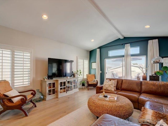 living room with lofted ceiling with beams, plenty of natural light, and light hardwood / wood-style flooring