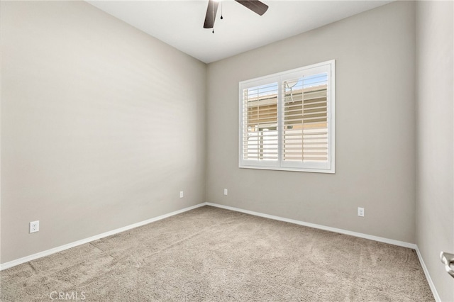 carpeted empty room featuring baseboards and a ceiling fan