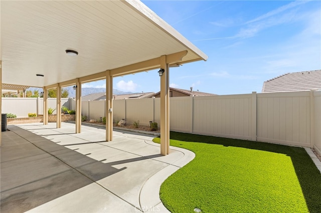 view of yard with a fenced backyard, central AC unit, and a patio