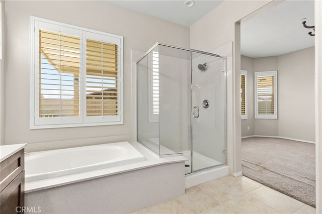 full bathroom featuring a garden tub, a stall shower, tile patterned flooring, and vanity