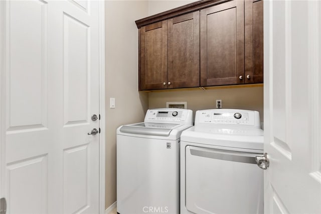 clothes washing area featuring washer and dryer and cabinet space