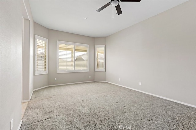 unfurnished room featuring baseboards, carpet floors, and a ceiling fan