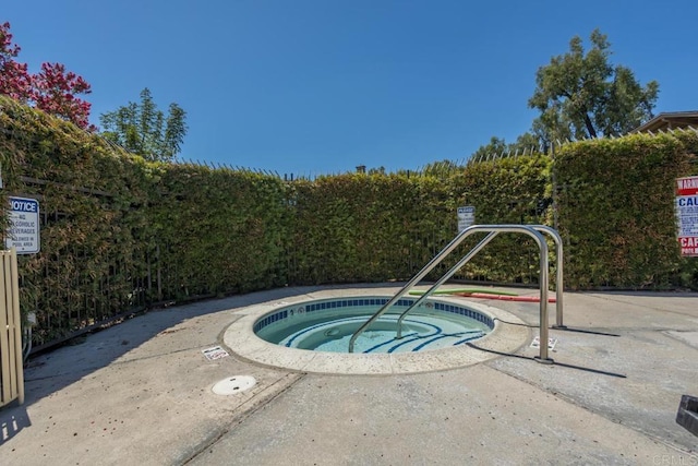 view of swimming pool with a hot tub