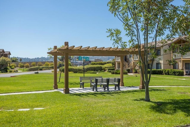 view of property's community with a pergola and a lawn