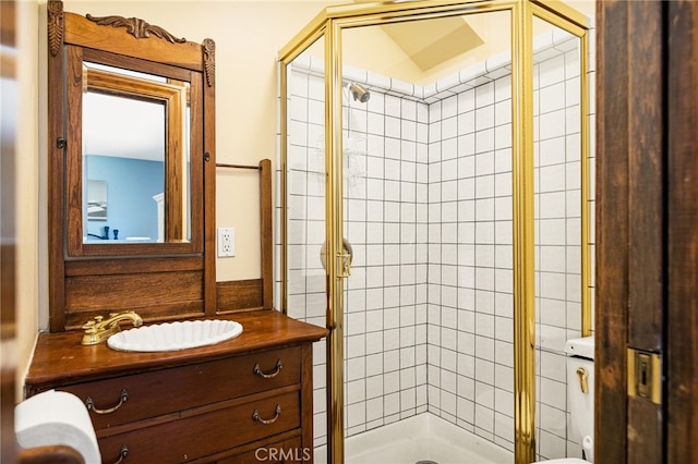 bathroom featuring a shower with door and vanity