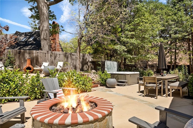 view of patio / terrace featuring a hot tub and an outdoor fire pit