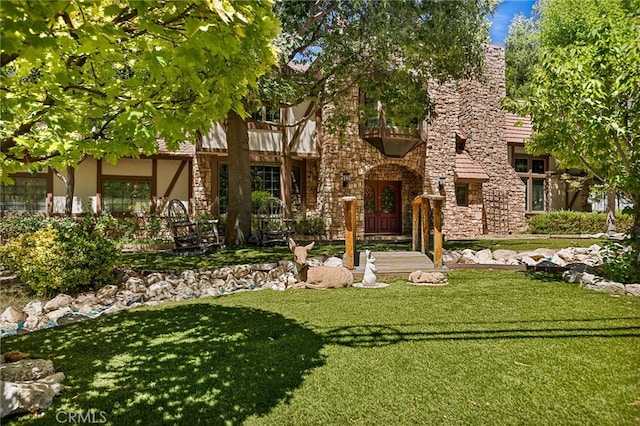 tudor home with a front lawn