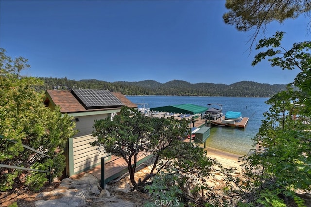 property view of water featuring a dock and a mountain view