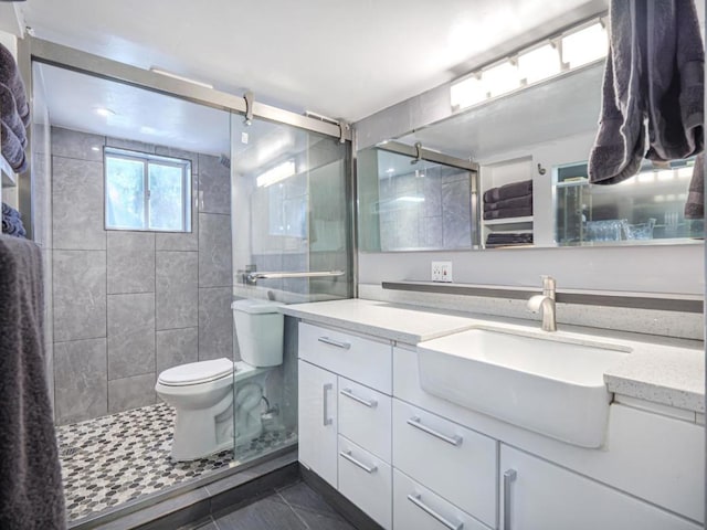 bathroom with vanity, tile patterned floors, toilet, and walk in shower