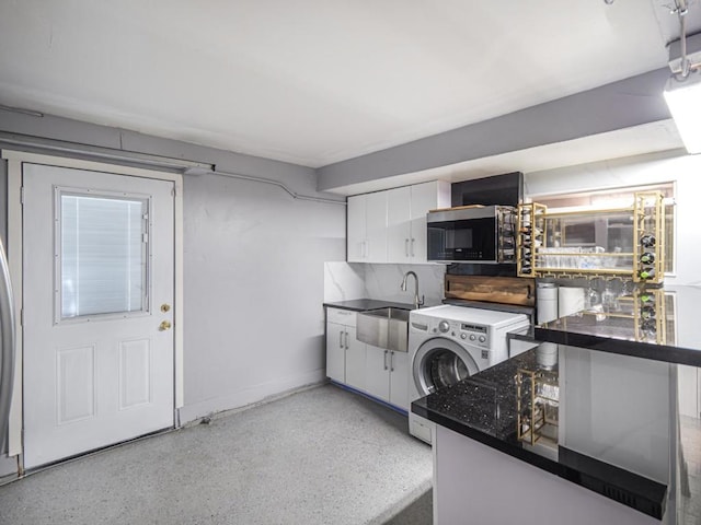 kitchen with washer / dryer, sink, white cabinets, and kitchen peninsula