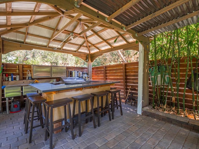 view of patio featuring a gazebo, exterior kitchen, and a bar