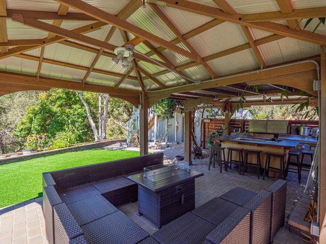 view of patio / terrace featuring a gazebo, ceiling fan, outdoor lounge area, and an outdoor bar