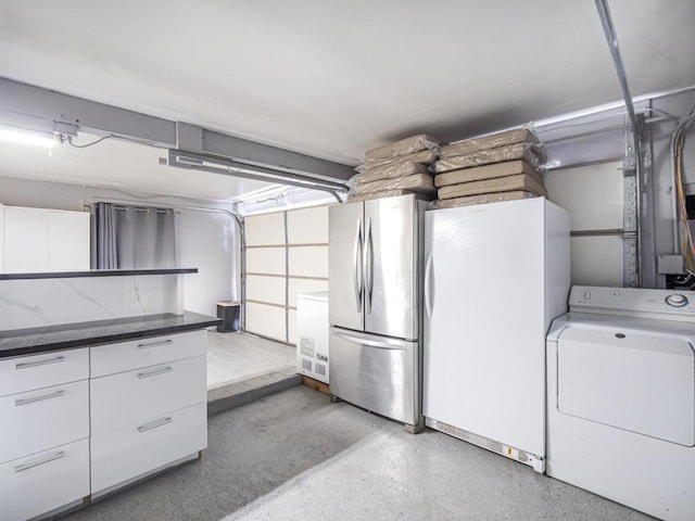 basement with washer / dryer, white fridge, and stainless steel refrigerator