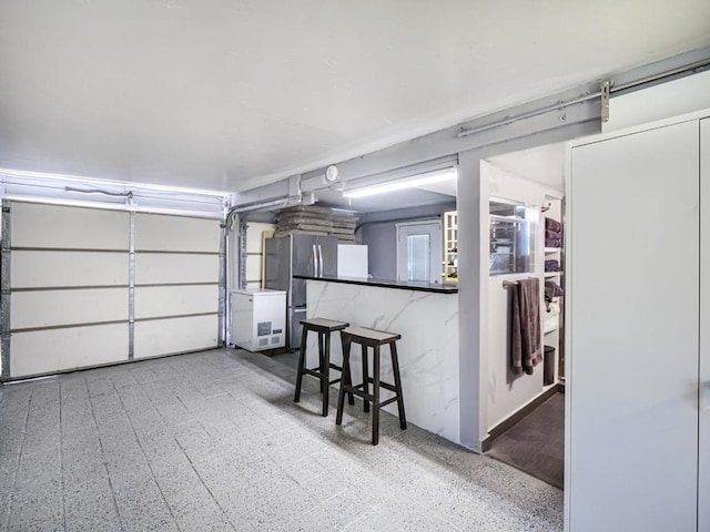 garage with stainless steel fridge