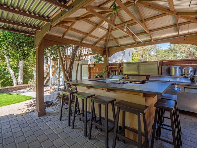 view of patio with area for grilling, a gazebo, and exterior bar