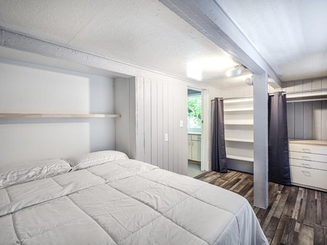 bedroom featuring dark hardwood / wood-style flooring and a textured ceiling