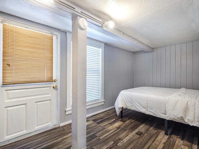 bedroom with dark hardwood / wood-style floors and a textured ceiling