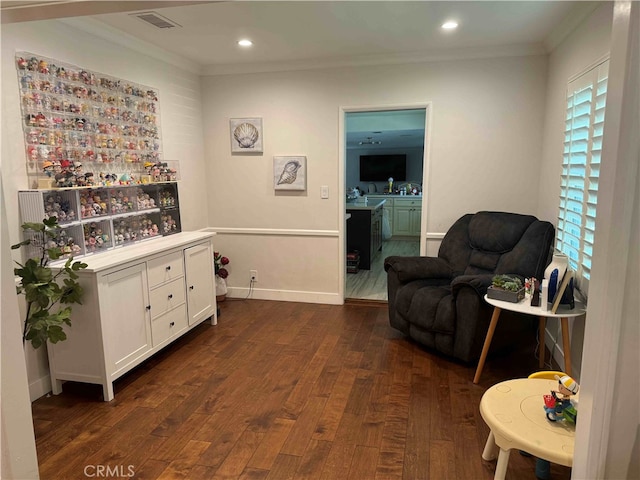 sitting room with ornamental molding and dark hardwood / wood-style floors