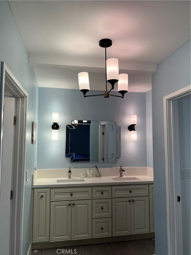 bathroom with an inviting chandelier, vanity, and hardwood / wood-style floors