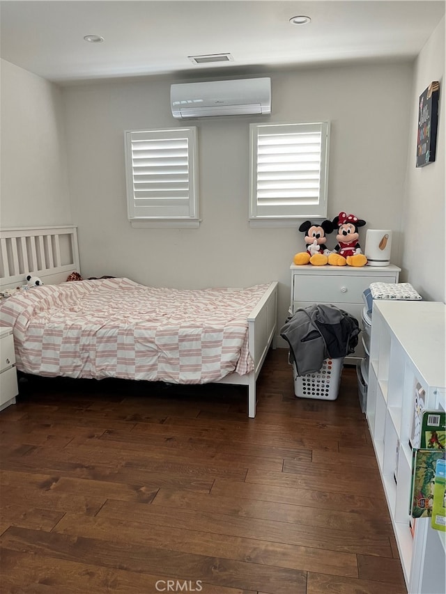 bedroom with dark wood-type flooring and a wall mounted AC