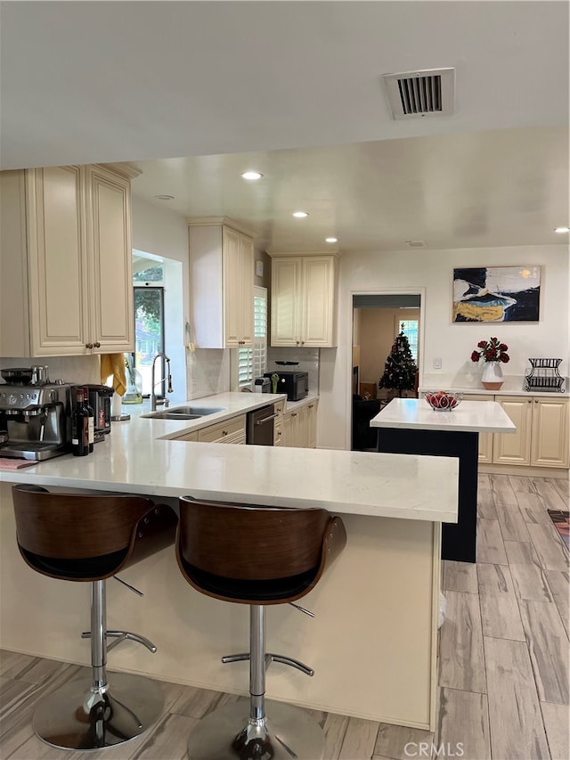 kitchen featuring a breakfast bar, kitchen peninsula, and light hardwood / wood-style flooring