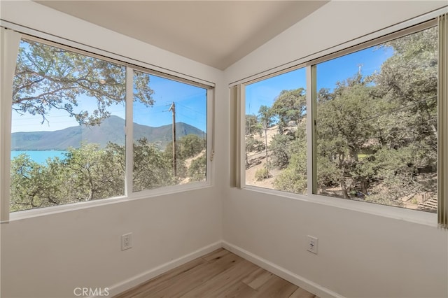 unfurnished sunroom with lofted ceiling and a mountain view