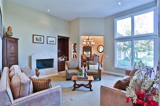 carpeted living room featuring a chandelier and a high ceiling