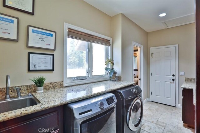 laundry area with washing machine and clothes dryer and sink