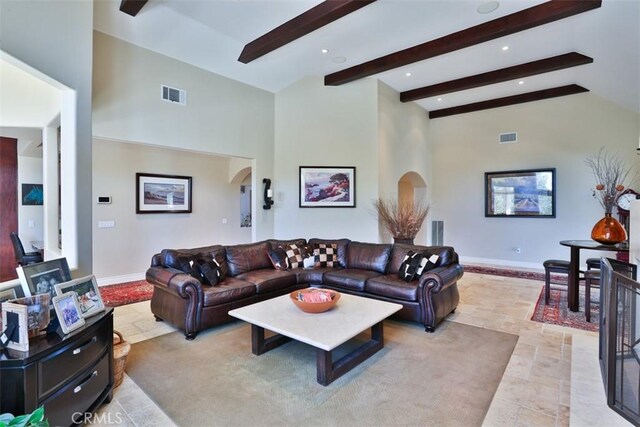 living room featuring beam ceiling and high vaulted ceiling