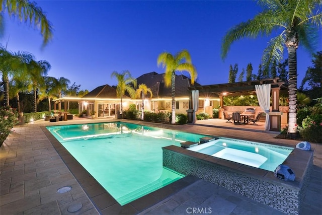 view of swimming pool featuring a patio area and an in ground hot tub