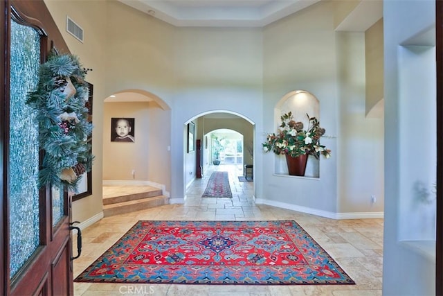 foyer entrance featuring a towering ceiling