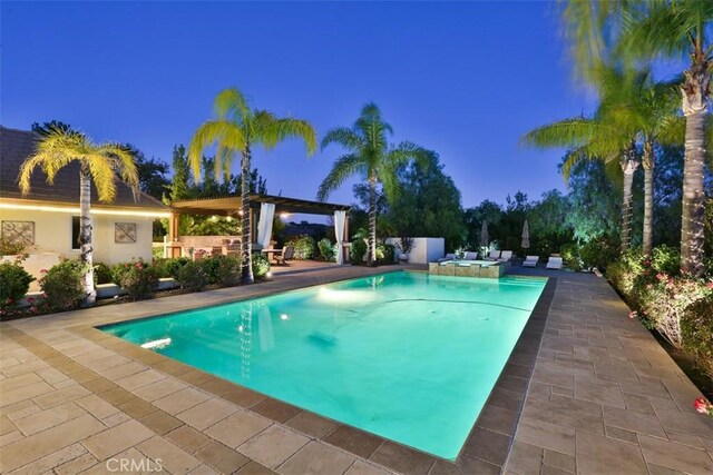 pool at dusk featuring a patio area