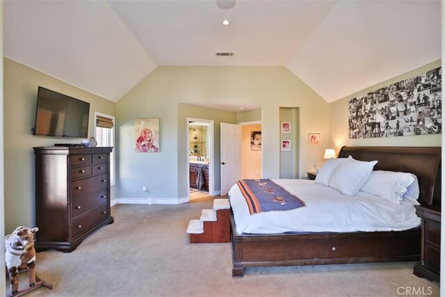 carpeted bedroom featuring lofted ceiling and connected bathroom