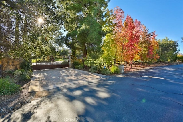 exterior space featuring aphalt driveway and a gated entry