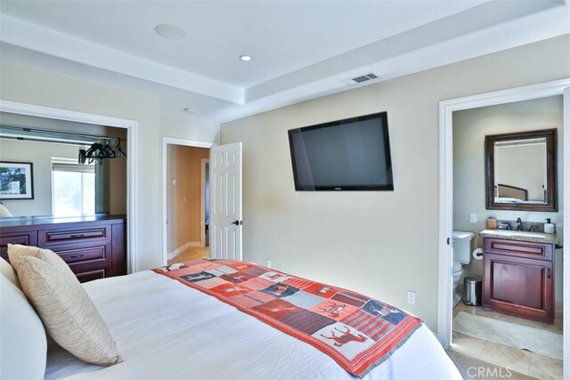 tiled bedroom with ensuite bathroom and sink