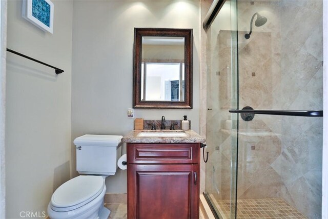 bathroom featuring vanity, toilet, and an enclosed shower