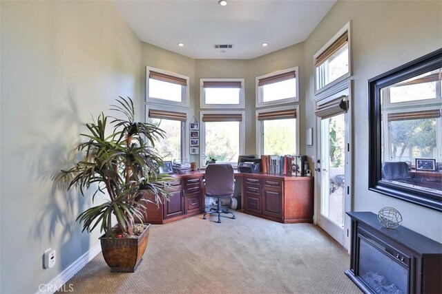 office with a wealth of natural light and light colored carpet